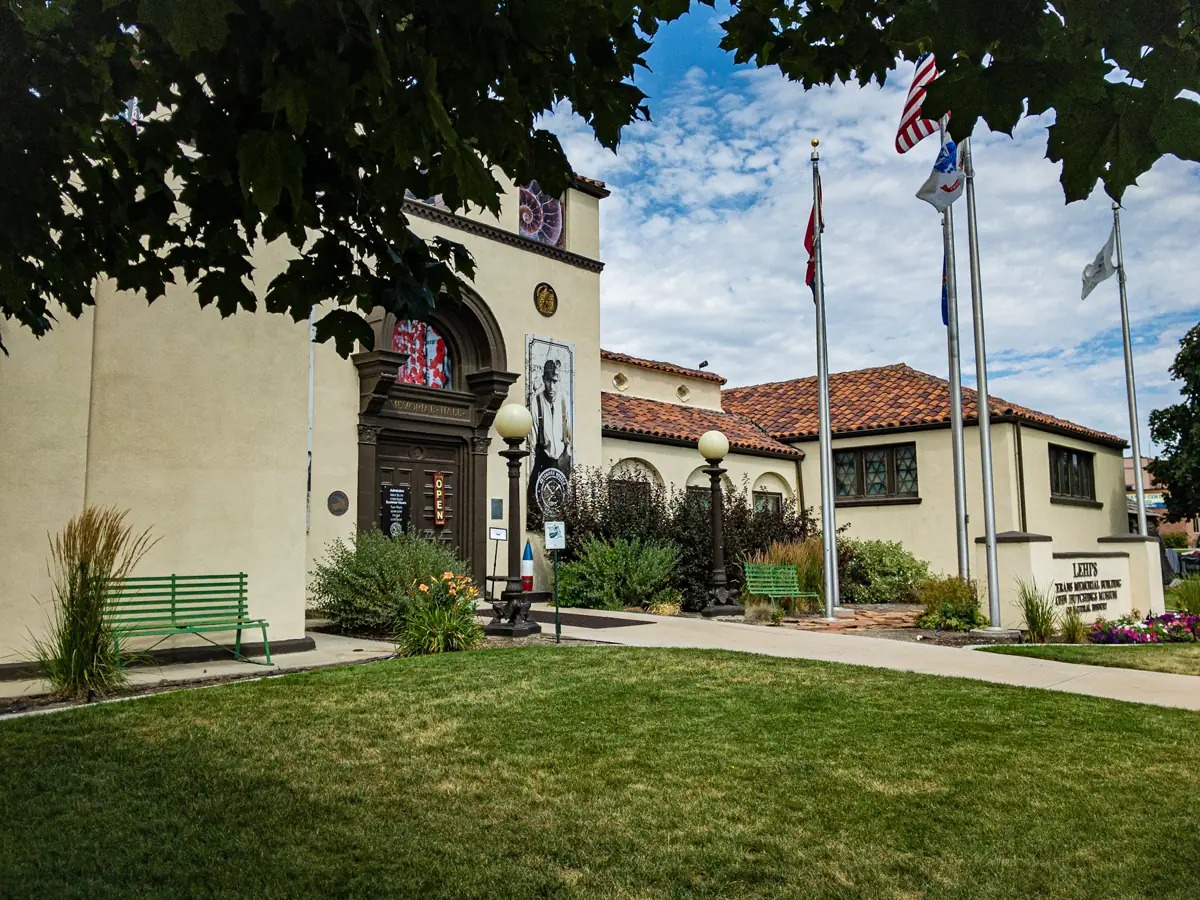 Veterans Memorial Building in Lehi, with trees and flags outside