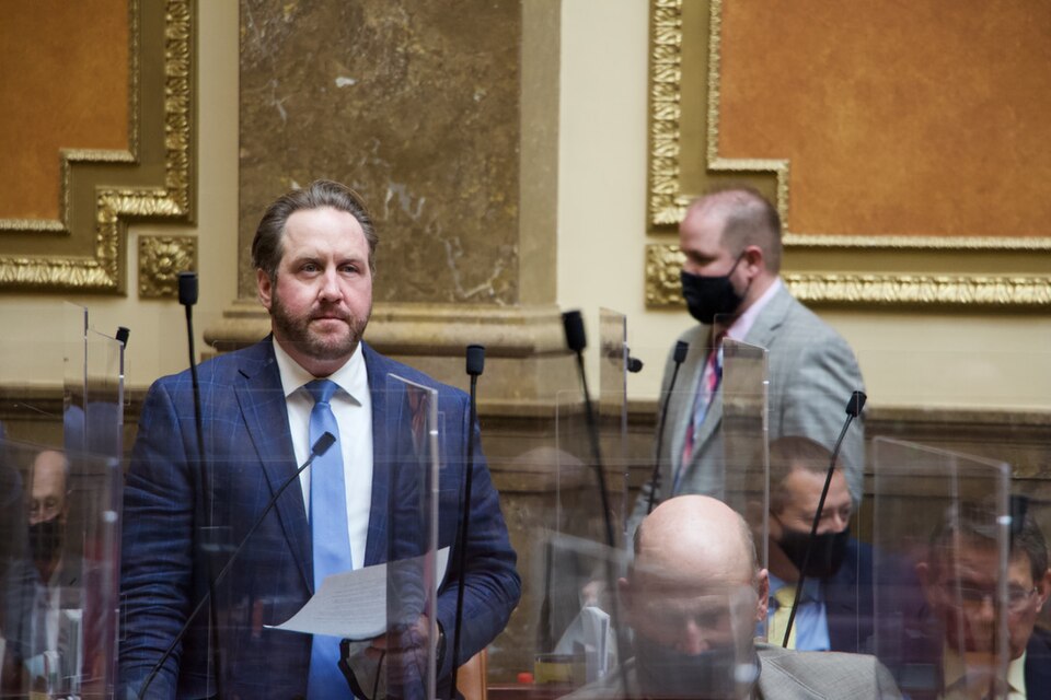 Jefferson Moss, standing at left in a blue suit, speaks on the Utah House floor in 2021.
