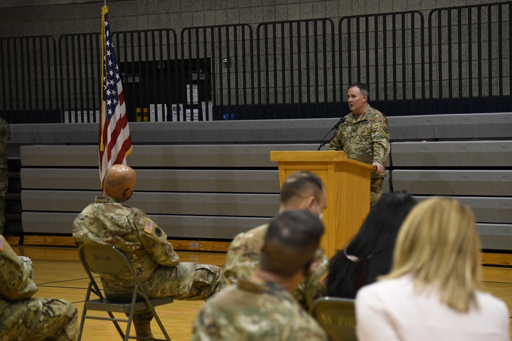 Tyler Smith speaks at a podium to soldiers and family members during a Utah National Guard farewell ceremony.