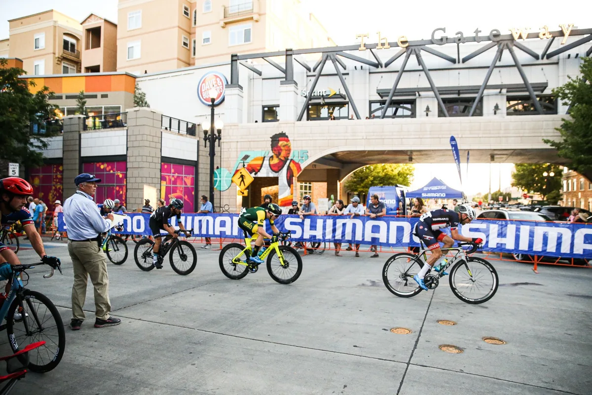 Cyclists riding past barriers at a Salt Lake City street race